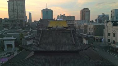 Günbatımında antik tapınağı olan modern şehrin havadan görünüşü