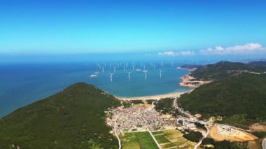 Denizde yel değirmenleri olan kıyı manzarası