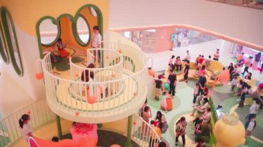 Çocuklar kapalı bir alışveriş merkezinde oyun oynuyorlar..