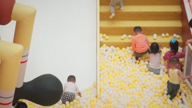 Çocuklar kapalı bir alışveriş merkezinde oyun oynuyorlar..