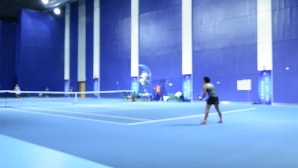 青い屋内コートでテニスをする女性の輝かしいビデオ映像 — ストック動画