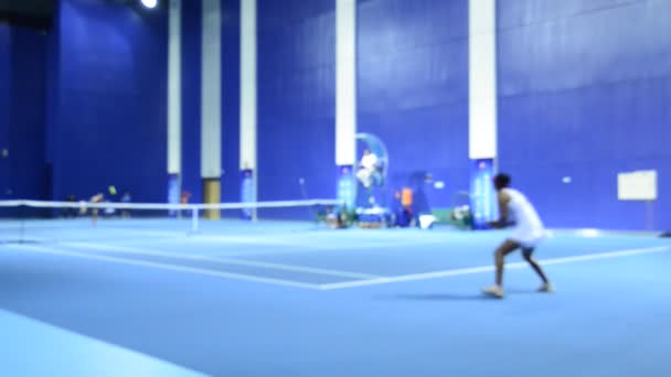 青い屋内コートでテニスをする女性の輝かしいビデオ映像 — ストック動画