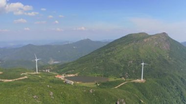 Dağlardaki rüzgar enerji istasyonunda dönen rüzgar türbinleri. Hava görünümü.