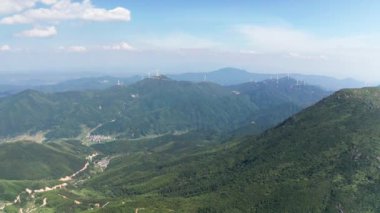 Dağlardaki rüzgar enerji istasyonunda dönen rüzgar türbinleri. Hava görünümü.