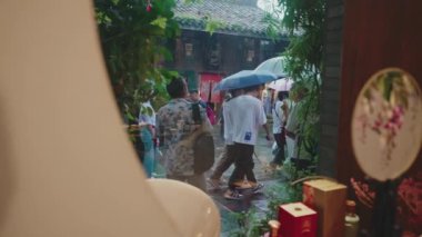 Çin 'deki antik bir kasabada yağmurun altında yürüyen insanlar.. 