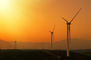 güç hattı günbatımında Rüzgar türbinleri