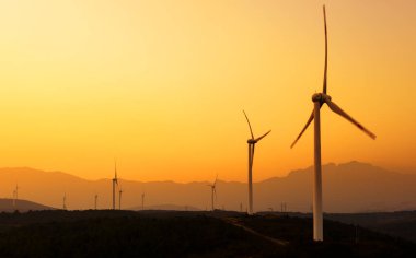 güç hattı günbatımında Rüzgar türbinleri