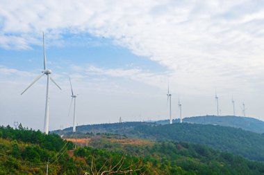 Bulutlu gökyüzünün önünde dönen rüzgar türbini