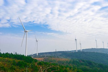 Bulutlu gökyüzünün önünde dönen rüzgar türbini