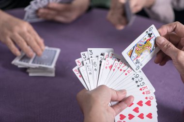 İnsanlar kartları kapalı çekimde oynarlar