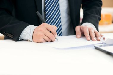 Kalemle yazı masasında uzanan iş adamının resmi 