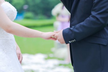 Düğün çifti el ele tutuşuyor.