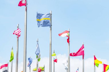 Rüzgardaki bayrak direkleri mavi bulutlu gökyüzüne karşı