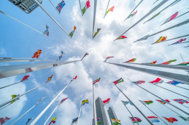 poles of flags in the wind against the blue cloudy sky clipart