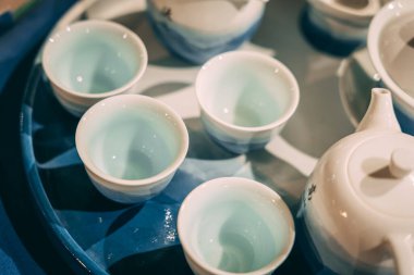 Masadaki beyaz ve mavi çay fincanlarını kapat.