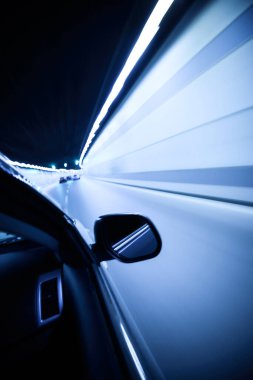 Mavi ışıklı soyut tünelde bir araba.