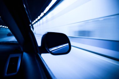 Mavi ışıklı soyut tünelde bir araba.