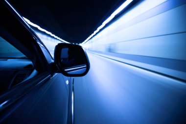 Mavi ışıklı soyut tünelde bir araba.