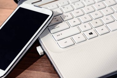 Ofisteki ahşap masada modern laptop ve telefon..