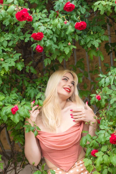 Красивая Женщина Длинными Светлыми Волосами Красными Губами Розовой Одежде Позирует — стоковое фото