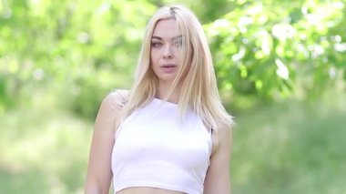 Olgun Sarışın Kadın Yeşil Park 'ta duruyor, Kameraya bakıyor, Kollar çapraz, Yatay Görüntü