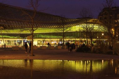 PARIS, FRANCE - 23 Şubat 2020: Forum des Halles alışveriş merkezi ve o akşam önündeki park. Işıklar, çeşme suyundaki yansımalar. Sosyalleşen ve alışveriş yapan insanların siluetleri.