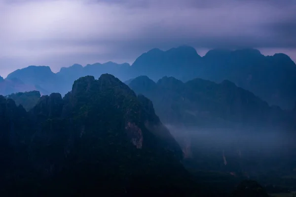 朝の青い霧を通して見られる影の山 — ストック写真