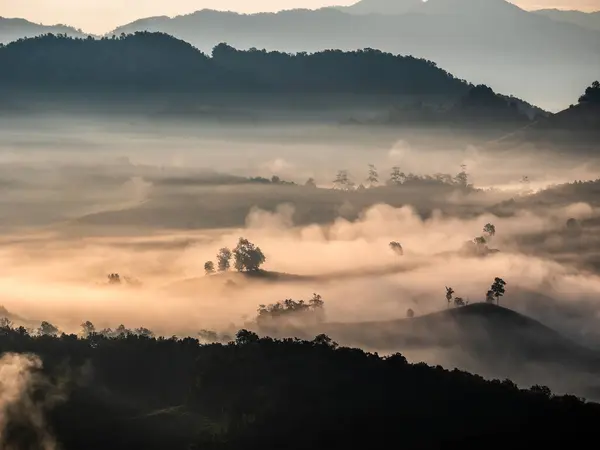 Die Strahlen Der Morgensonne Durch Den Nebel Den Bergen lizenzfreie Stockfotos