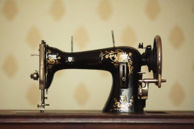 Retro konsept. Giysi atölyesindeki vintage dikiş makinesinin ön tarafını kapatın. Kapalı çekim