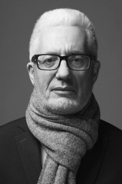 Her yaş kavramında harikadır. Gri arka planda duran, modaya uygun aksesuarlar takan 60 yaşındaki bir iş adamının portresi. Klasik bir tarz. Stüdyo çekimi