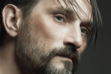 Her yaş kavramında harikadır. Koyu gri arka planda duran 45 yaşındaki bir adamın profil portresi. Islak saçlar. Kapatın. Stüdyo çekimi