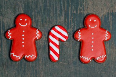 Noel gingerbread çerezleri şeklinde kırmızı gingerbread erkek çizgili tatlılar, şekerler eski vintage rustik ahşap masa merkezinde yalan. Retro tarzı. Düz yatıyordu fotoğraf