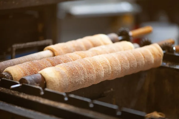 Trdelnik or trdlo on a showcase shop, Kind of spit cake made from rolled dough wrapped around a stick, grilled and topped with sugar, walnut mix. Prague, Czech Republic. Indoor shot