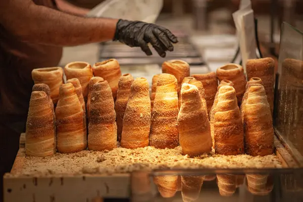 Trdelnik or trdlo on a showcase shop, Kind of spit cake made from rolled dough wrapped around a stick, grilled and topped with sugar, walnut mix. Prague, Czech Republic. Indoor shot