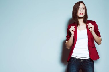 Modern ofis çalışanı konsepti. Moda kıyafetler giyen ve açık mavi arka planda poz veren güzel bir kızın portresi. Mükemmel cilt ve makyaj. Zekice bir gündelik tarz. Kopyalama uzayı. Stüdyo çekimi