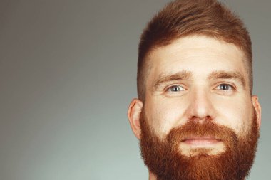Her yaşta müthiştir. Açık gri arka planda poz veren 30 yaşında, kızıl saçlı, karizmatik kaslı bir adamın portresi. Mükemmel saç kesimi. Stüdyo çekimi