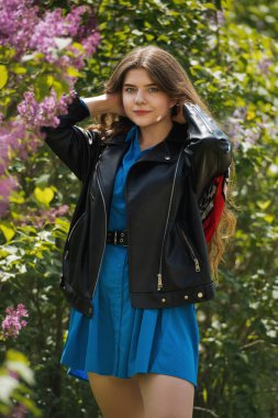 Etrafı leylak çiçekleriyle çevrili güzel bir kadın..