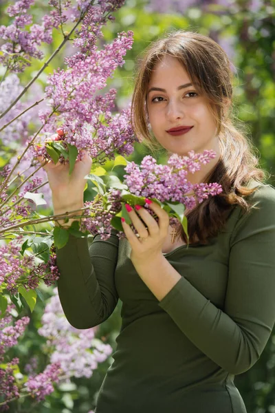 Etrafı leylak çiçekleriyle çevrili güzel bir genç kadının portresi..