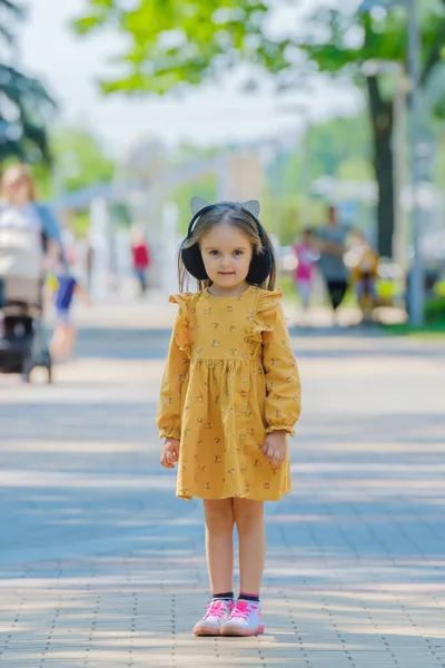 Sarı Elbiseli Küçük Bir Kız Sokakta Duruyor — Stok fotoğraf