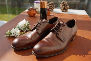 Damat aksesuarlarını hazırla. Erkek ayakkabısı, yaka çiçeği. Yumuşak odak.