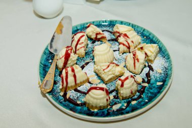 Tabakta peynirli kek parçaları var. Şeker çubuğu.