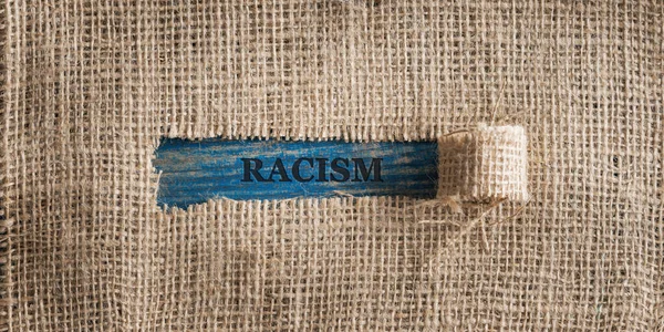 Ortasında Irkçılık Yazan Yırtık Bir Pencere Olan Pürüzlü Keten Kumaşın — Stok fotoğraf