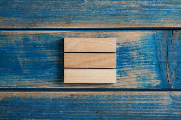 Hromada Tří Jednoduchých Prázdných Dřevěných Kolíků Umístěných Tvarovaném Dřevěném Pozadí — Stock fotografie