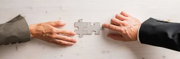 シンプルな木製の背景に2つの空白のパズルピースに一致する男性と女性のビジネスパートナーのトップビュー ワイドビュー画像 — ストック写真