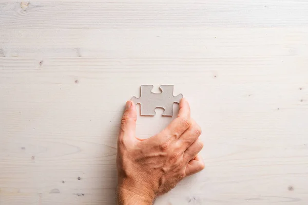 Draufsicht Der Männlichen Hand Die Leeres Puzzleteil Über Einfachen Holzhintergrund — Stockfoto