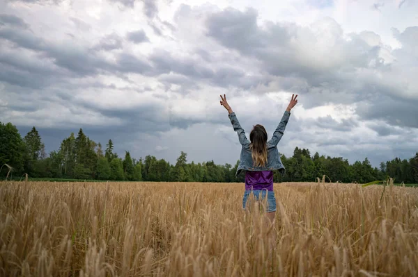 一个年轻女子站在金色的夏季麦田里 高举双臂 高高地享受着胜利的生活 这让人回首往事 — 图库照片