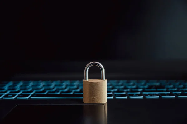 在开放的黑色笔记本电脑上安装了一个金色挂锁 上面有一个在线数据和密码保护的概念图 — 图库照片