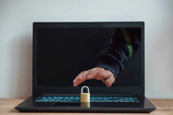 Mężczyzna Ręka Wyciągając Laptop Komputer Ekran Próbuje Ukraść Złoty Kłódka — Zdjęcie stockowe