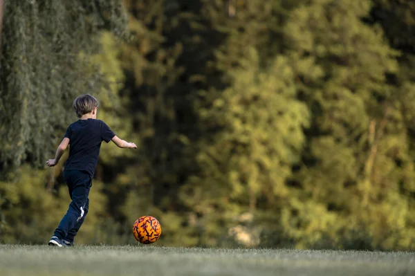 Jonge Jongen Trapt Een Bal Buiten Groene Weide Voetbalveld — Stockfoto