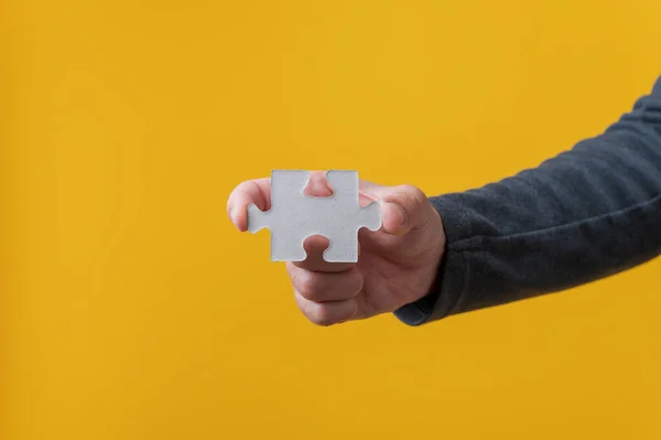 Männliche Hand Hält Leeres Puzzleteil Über Leuchtend Gelbem Hintergrund — Stockfoto